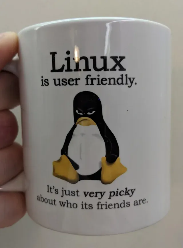 머그컵에 'Linux is user friendly. It's just *very picky* about who its friends are.'라는 문구와 함께 눈을 흘기고 있는 턱스의 그림이 인쇄되어 있다.